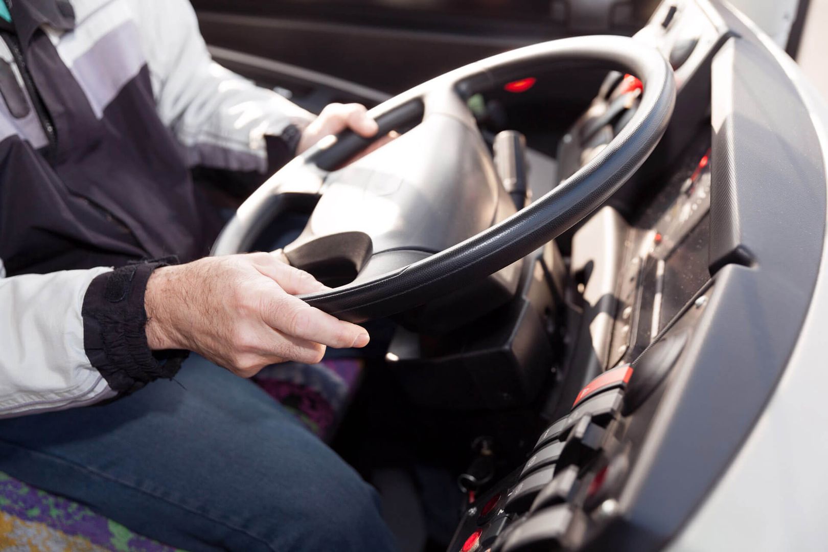 Ein Busfahrer hält das Lenkrad